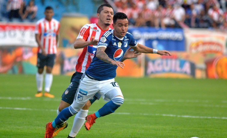 BARRANQUILLA - COLOMBIA - 18 - 03 - 2018: Leonardo Pico (Izq.) jugador de Atletico Junior disputa el balón con Santiago Montoya (Der.) jugador de Millonarios durante partido de la fecha 9 entre Atletico Junior y Millonarios por la Liga Aguila I-2018, jugado en el estadio Metropolitano Roberto Melendez de la ciudad de Barranquilla. / Leonardo Pico (L) player of Atletico Junior vies for the ball with Santiago Montoya (R) player of Millonarios during a match of the 9th date between Atletico Junior and Millonarios for the Liga Aguila I - 2018 at the Metropolitano Roberto Melendez Stadium in Barranquilla city, Photo: VizzorImage  / Alfonso Cervantes / Cont.